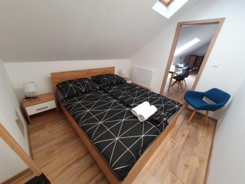 a bedroom with a bed with a mirror and a blue chair at M10 Apartman in Pécs