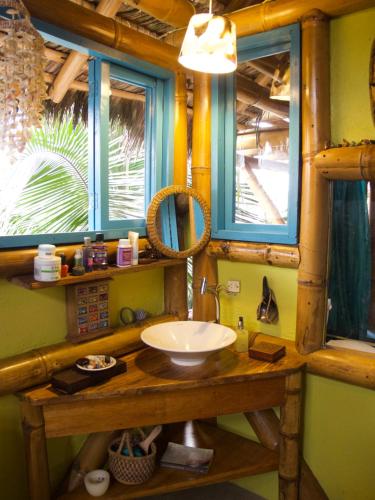 baño con lavabo y 2 ventanas en Simply Paradise en Mompiche