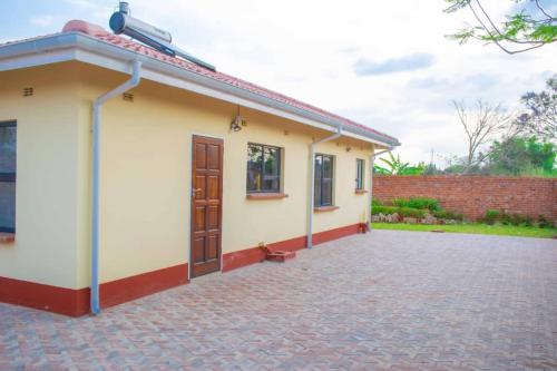 a small house with a brick driveway at Lynm Residence in Harare