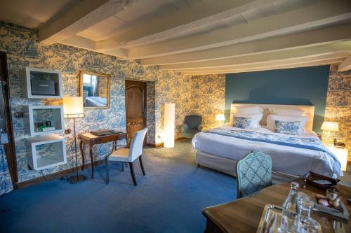 a bedroom with a large bed and a desk and a table at Château de Mercuès in Mercuès