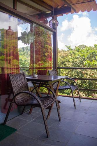 a patio with a table and chairs on a balcony at Pousada Aquarela in Morro de São Paulo