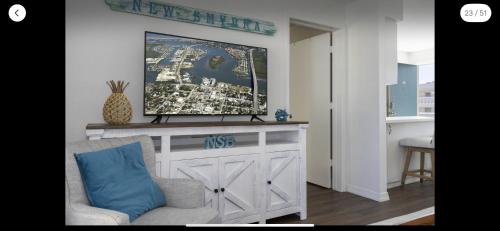 a living room with a tv on top of a table at Coastal Waters 209 in New Smyrna Beach