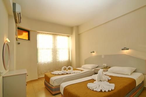 a hotel room with two beds with towels on them at Magi Apart Hotel in Alanya
