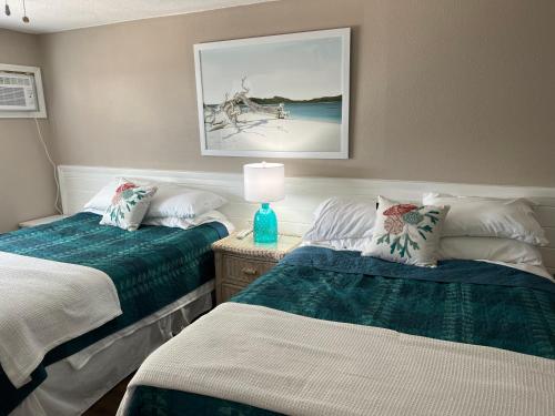 ニュー・スマーナ・ビーチにあるCoastal Waters 209のベッドルーム1室(ベッド2台、テーブルの上にランプ付)