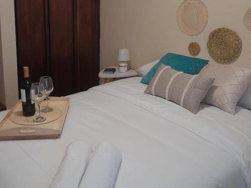 a white bed with wine glasses and a table with wine bottles at The Temple, Quito in Quito