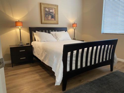 a bedroom with a black bed with white sheets and two lamps at Luxurious Condo at the Springs by Cool Properties in Mesquite