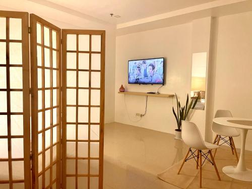 a living room with a television and a table at Japandi-inspired Hideaway in Dumaguete