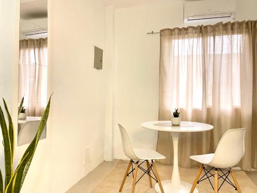 une salle à manger blanche avec une table et des chaises dans l'établissement Japandi-inspired Hideaway, à Dumaguete