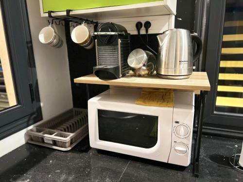 a microwave sitting on top of a table next to a coffee maker at Charmant appartement avec terrasse, vue sur lagon in Mamoudzou