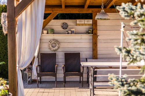 a patio with two chairs and a table at APARTEMENTY ''WERANDA'' z ogrodem w centrum in Kudowa-Zdrój