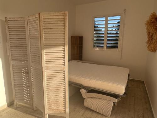 a hospital room with a bed and a window at Studio La Normantillaise in Petit-Bourg