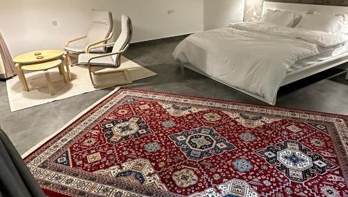 una camera con un letto e un tappeto sul pavimento di Dune Chalet شالية ديون ad Al Wāşil