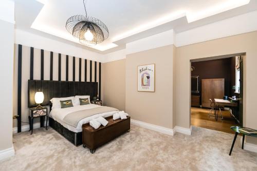 a bedroom with a large bed and a desk at Hillthorpe Manor by Maison Parfaite - Large Country House with Hot Tub in Pontefract