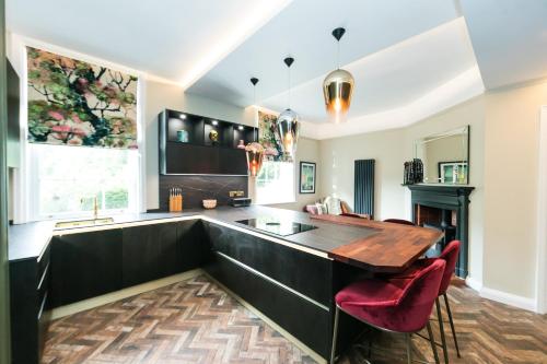 a kitchen with a wooden table and red chairs at Hillthorpe Manor by Maison Parfaite - Large Country House with Hot Tub in Pontefract