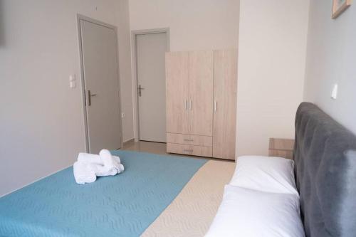 een slaapkamer met een bed en handdoeken op de vloer bij Anesis Airport rooms 102 in Koropíon