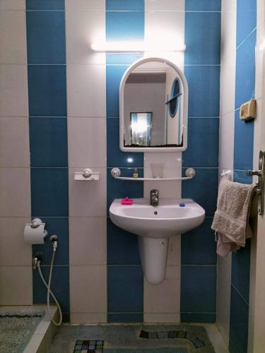 a bathroom with a sink and a mirror at Dans résidence à bord de la mer avec plage privée in Chott Meriem