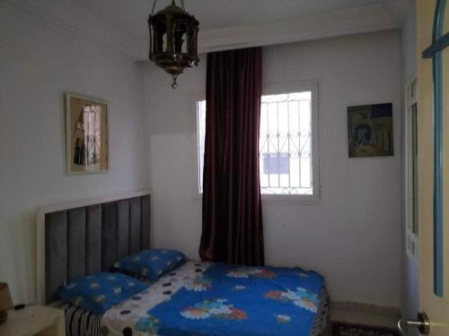 1 dormitorio con cama y ventana en Dans résidence à bord de la mer avec plage privée en Chott Meriem