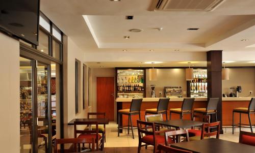 a restaurant with tables and chairs and a bar at Cresta Mahalapye Hotel in Mahalapye