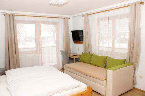 a living room with a couch and a tv and windows at Riverhaus in Schladming