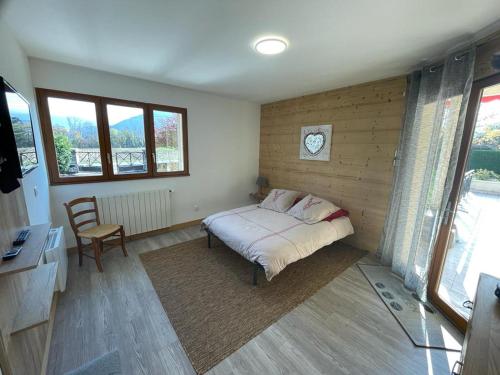 1 dormitorio con 1 cama y reloj en la pared en Chambre de la Tournette, en Saint-Jorioz