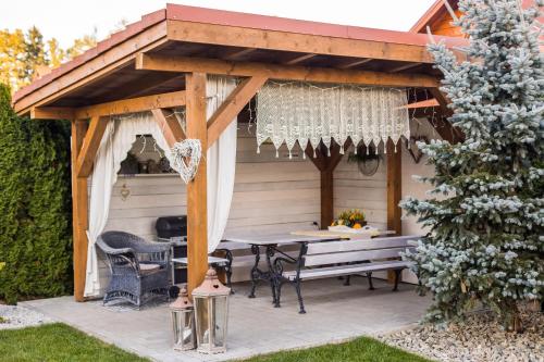 a wooden pergola with a picnic table in a backyard at APARTEMENTY ''WERANDA'' z ogrodem w centrum in Kudowa-Zdrój