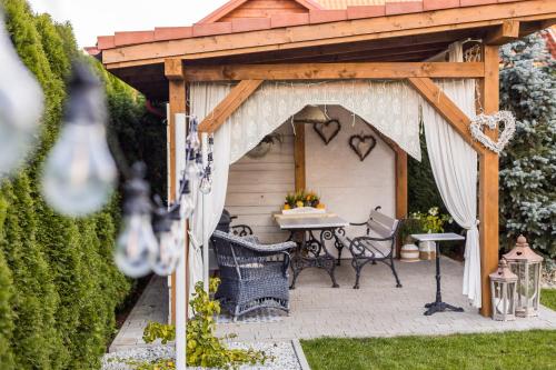 a pergola with a table in a garden at APARTEMENTY ''WERANDA'' z ogrodem w centrum in Kudowa-Zdrój
