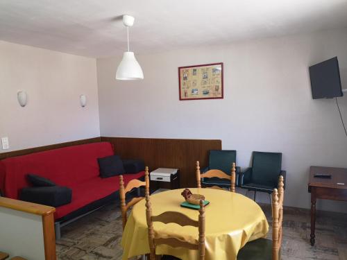 - un salon avec un canapé rouge et une table dans l'établissement St Roch La Casalle - BOYER locations, à Ax-les-Thermes