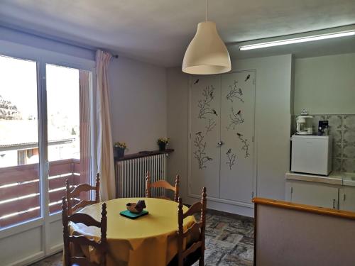 une salle à manger avec une table et une cuisine dans l'établissement St Roch La Casalle - BOYER locations, à Ax-les-Thermes