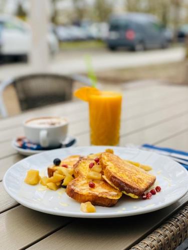a white plate with toast and fruit on a table at Domki letniskowe Wiga in Kołobrzeg