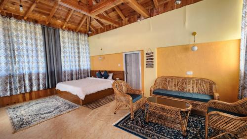 um quarto com uma cama e cadeiras num quarto em Neelkanth Retreat Mukteshwar em Mukteswar