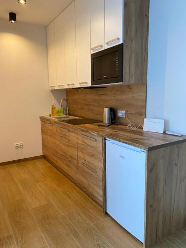 a kitchen with a white refrigerator and a microwave at Apartament Korczyńskiego 29 in Zakliczyn