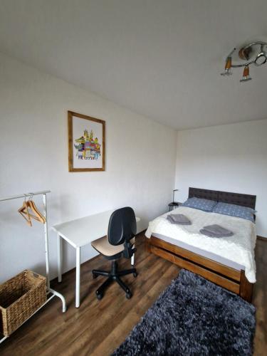 Schlafzimmer mit einem Bett, einem Schreibtisch und einem Tisch in der Unterkunft Apartmán Siesta in Poprad