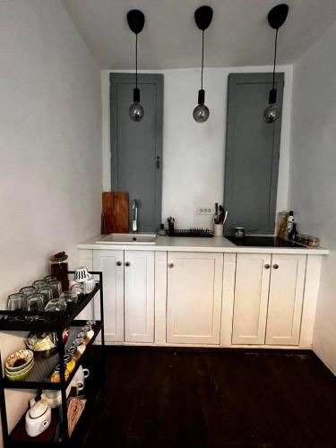 uma cozinha com armários brancos e um lavatório em Sentina kuća em Vrtovac