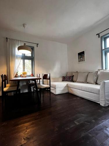 uma sala de estar com um sofá branco e uma mesa em Sentina kuća em Vrtovac