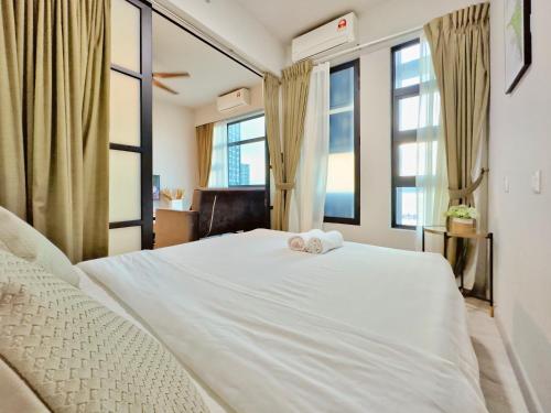 a bedroom with a white bed with two towels on it at #9 Jesselton Quay City Pads Seaview by Zeluxo in Kota Kinabalu