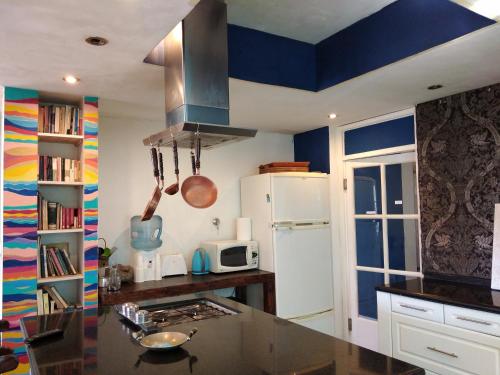 uma cozinha com paredes azuis e brancas e um balcão em Casa con piscina a 5 minutos del centro em El Challao