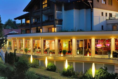 a hotel with a lit up facade at night at Hotel Rosenstock - Erwachsenenhotel - Adults only 15 plus in Fischen