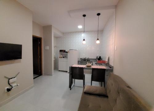 a kitchen with a table and chairs in a room at Flats Ipê in Pirenópolis