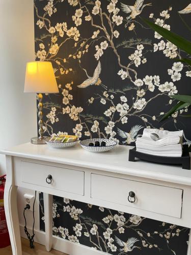 a white dresser with a black and white wallpaper at Artist House Amsterdam in Amsterdam