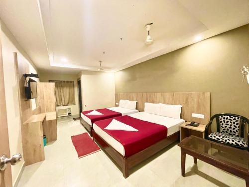 ein Schlafzimmer mit einem Bett und einem Stuhl darin in der Unterkunft Hotel Janaki Pride, Puri fully-air-conditioned-hotel spacious-room with-lift-and-parking-facility in Puri