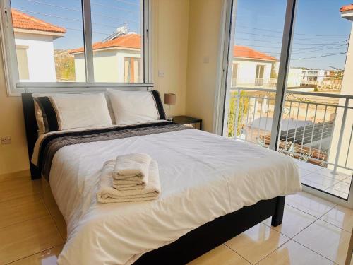 una cama con una toalla delante de una ventana en Athena Villa, en Lárnaca