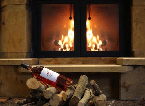 a bottle of wine on logs in front of a fireplace at HEAVEN HOUSE in Kavala