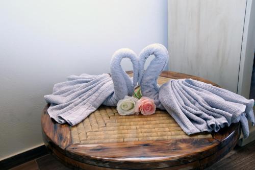 two towels and flowers on top of a table at HEAVEN HOUSE in Kavala