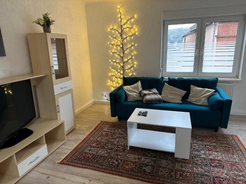 ein Wohnzimmer mit einem blauen Sofa und einem Tisch in der Unterkunft Ferienwohnung 2, 1. OG Nähe Augenklinik in Sulzbach