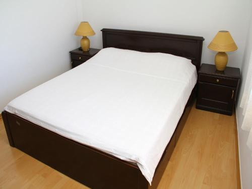 a bedroom with a large bed with two night stands at Holiday Home Blaž in Primošten