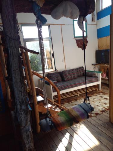 eine Schaukel in einem Zimmer mit Sofa und Fenster in der Unterkunft Casa del mar in Balneario Mar Chiquita