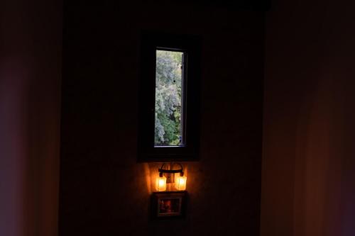 a window in a dark room with a light on it at Vila IRA in Veria