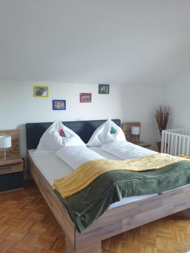 a bedroom with a large bed with a green blanket on it at Appartement Gamlitz in Gamlitz