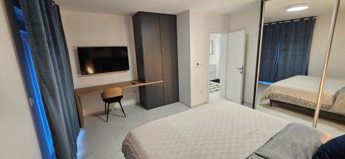 um quarto com uma cama e uma secretária com uma televisão em Superior Apartment Lisinski - Private parking - 2 & 3 Bedroom em Zagreb