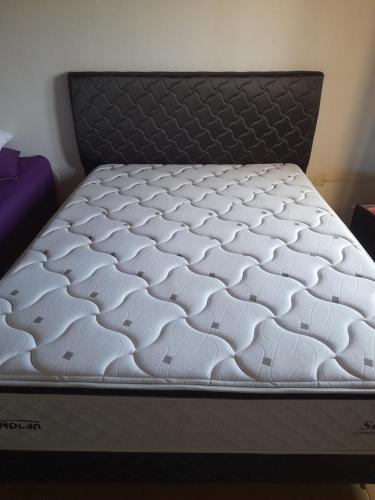 a white mattress on a bed frame in a room at AparWil in Encarnación